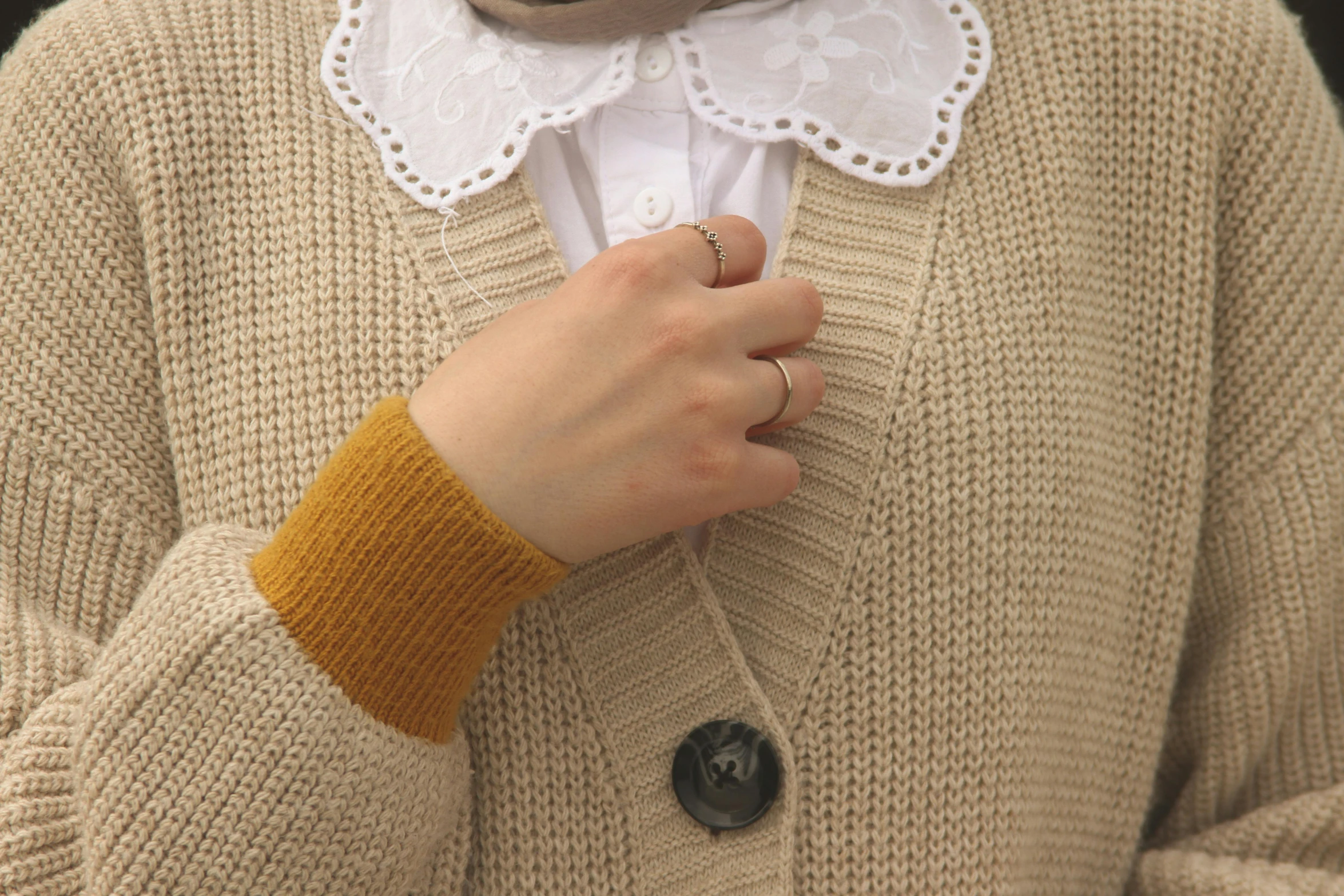 the lady wears a white collar and sweater