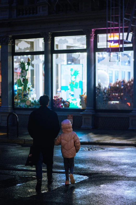 the child in a pink coat is being held by an adult