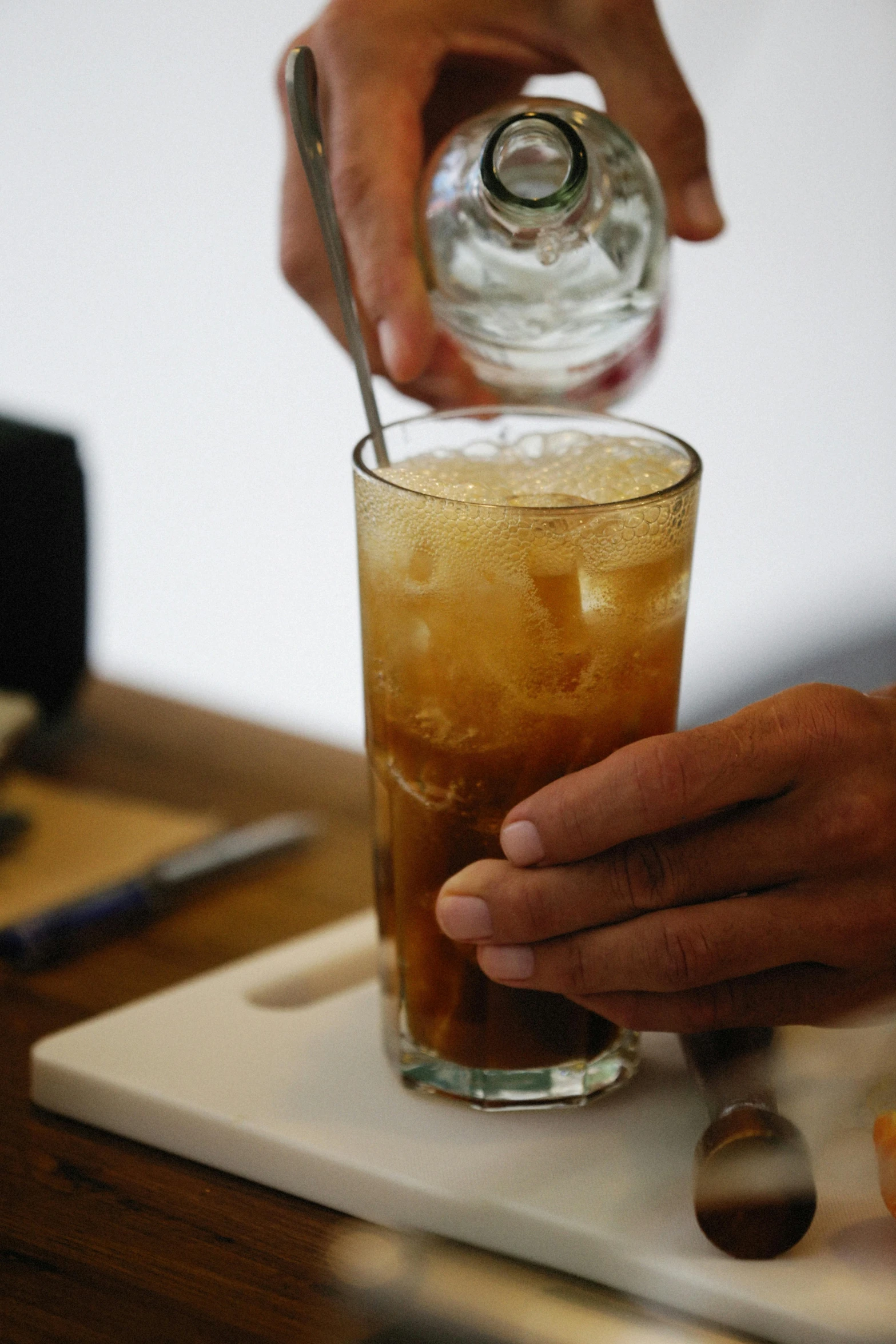 the hand is pouring liquid onto the drink