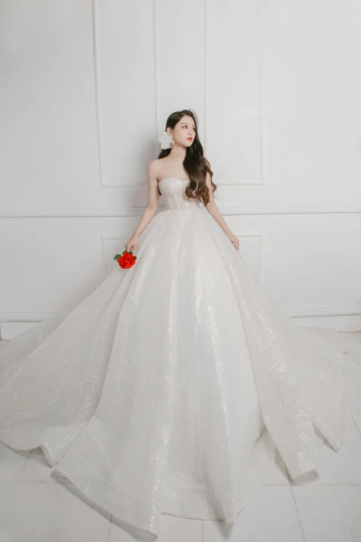 a woman in a white gown holding a flower