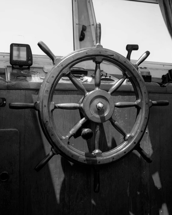 an old ship steering wheel on the deck