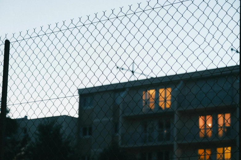 a picture of a sunset through a chain link fence