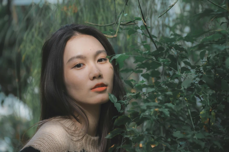 a beautiful woman standing behind some nches with orange lipstick