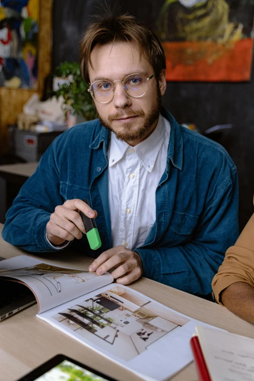 a man sitting at a table in front of an open book