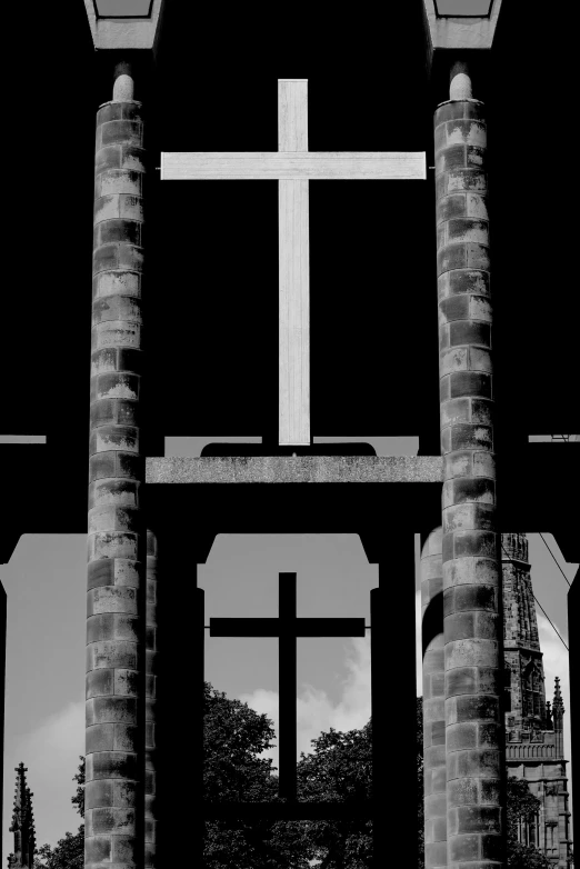 the cross stands in front of two pillars