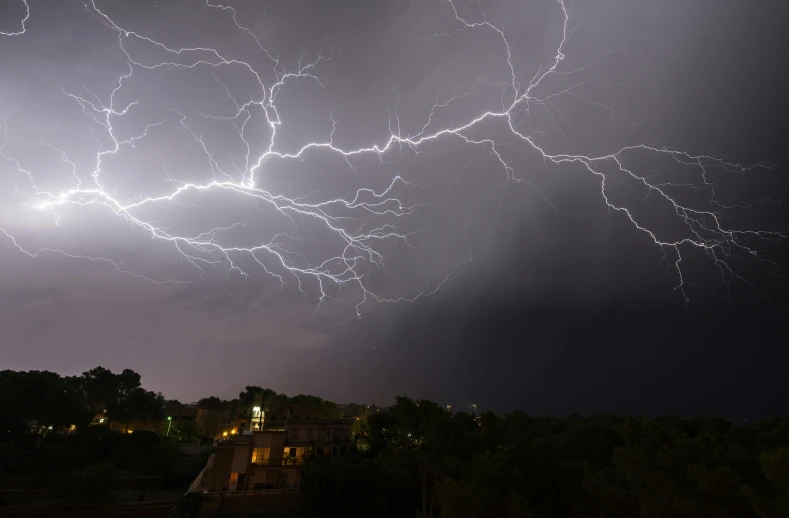 large lightning striking over a residential area in the city