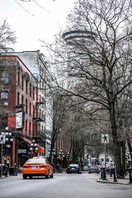 cars drive along the side of a road near tall buildings