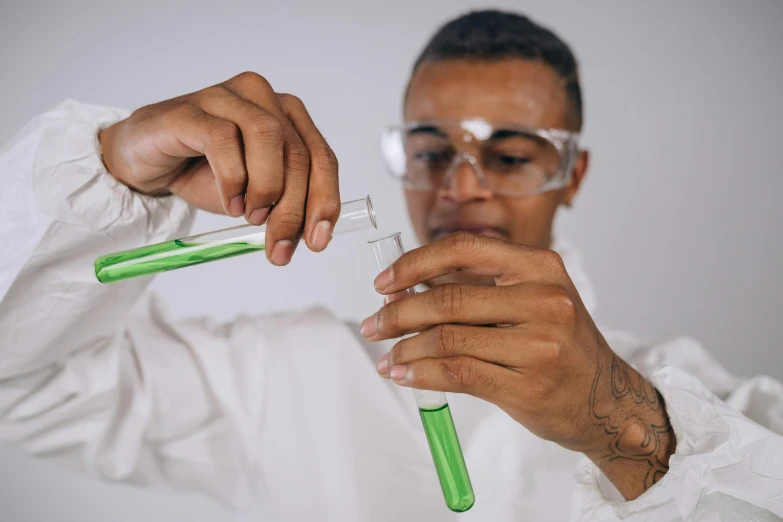 a man holding a test tube filled with liquid