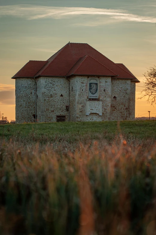 an old rusty building with grass in front of it