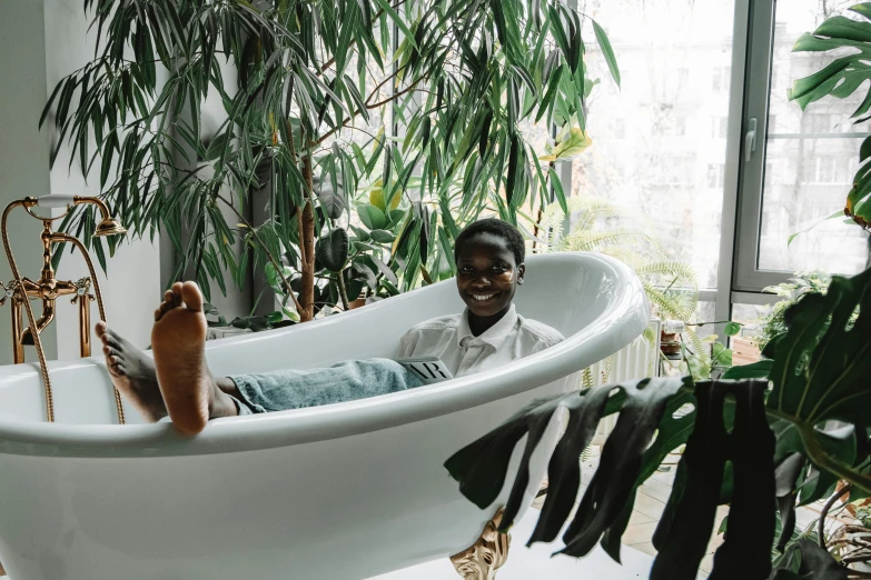 a man is sitting in the bathtub with one foot in it