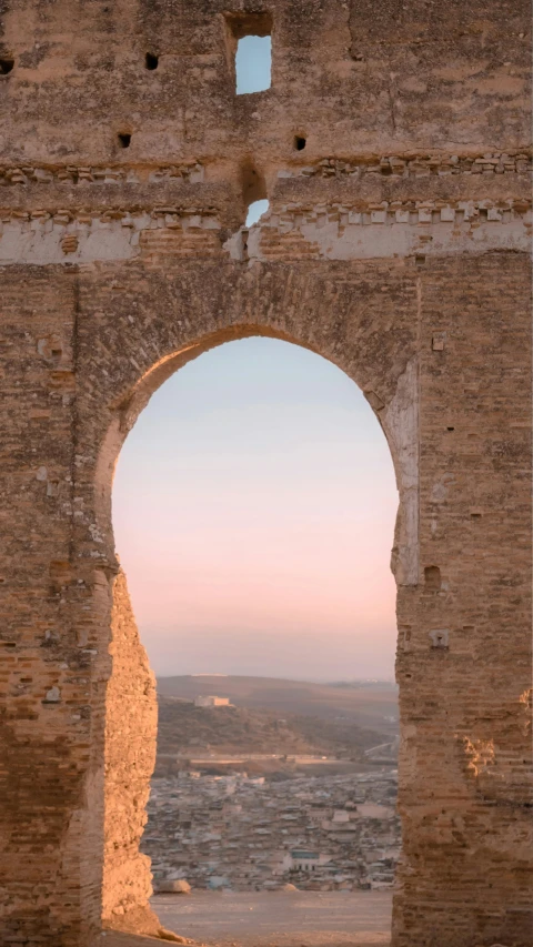 a window view of an old building with a sky view