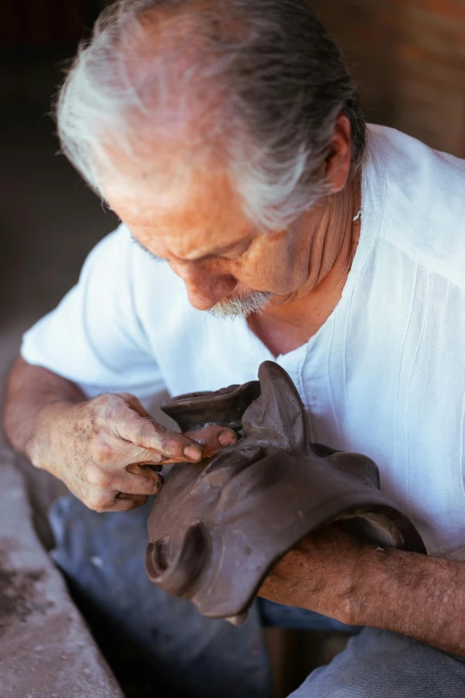 the older man is putting soing into the clay