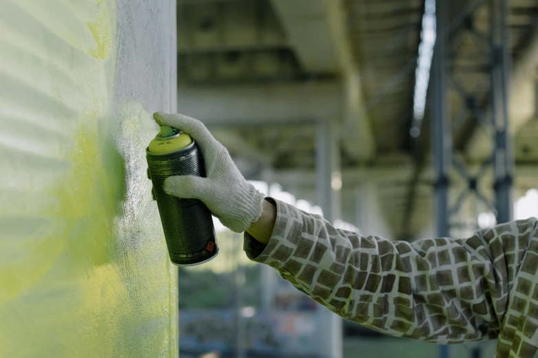 someone spray painting the side of a wall