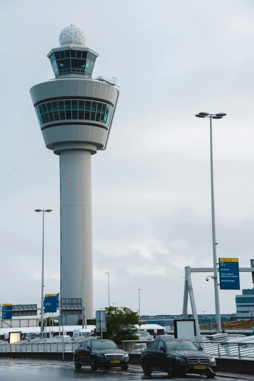 an airport building with a traffic sign and some cars parked near it