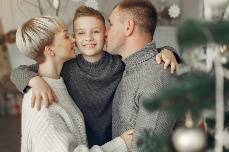 a family hugging while under the christmas tree