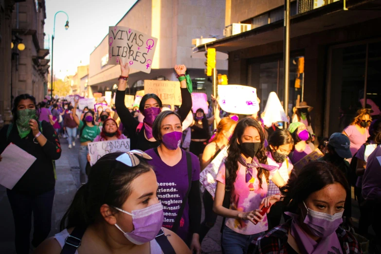 a group of people holding up signs and masks