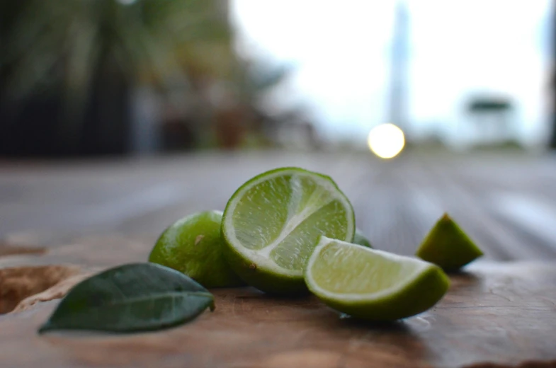 limes on a wood table ready to be sliced