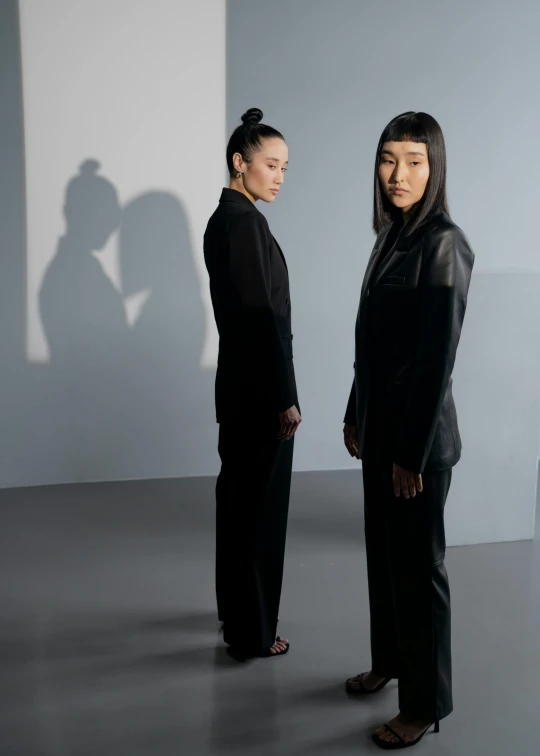 two women stand in the middle of a dimly lit room