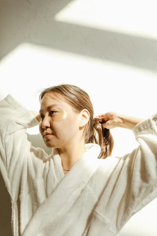 a woman with ponytails standing by a wall