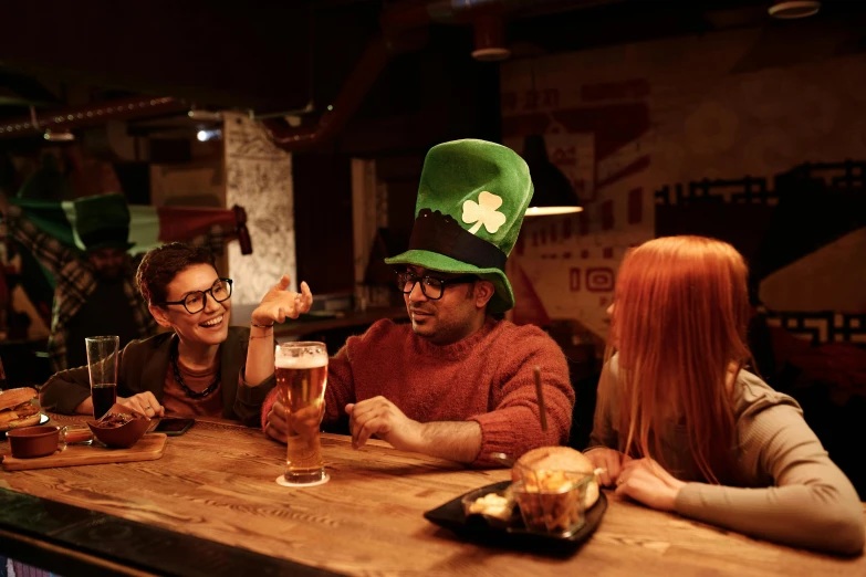 group of people in st patrick's day outfit sitting at a bar eating