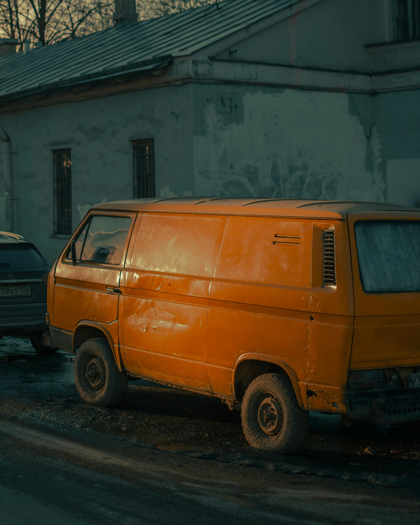 an orange van is parked in front of an abandoned building