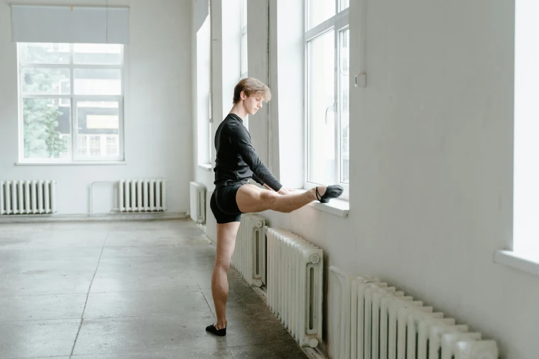 a woman is standing on the window sill and touching the side of a wall