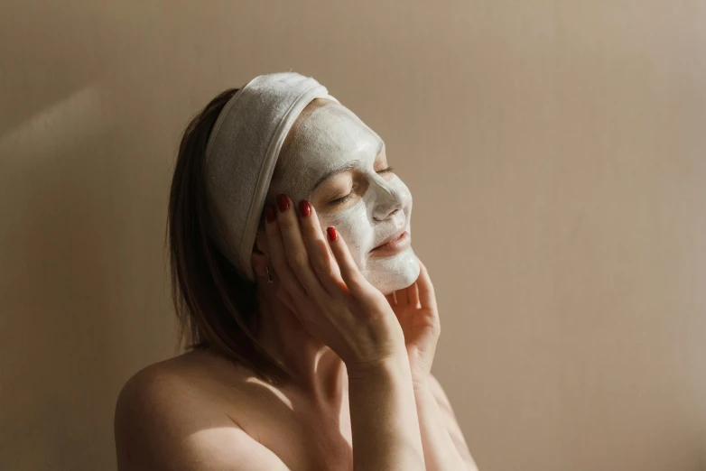 a woman with a face mask on looking at herself in the mirror