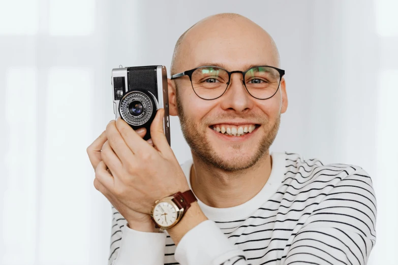 a man holding up an old camera to take a picture