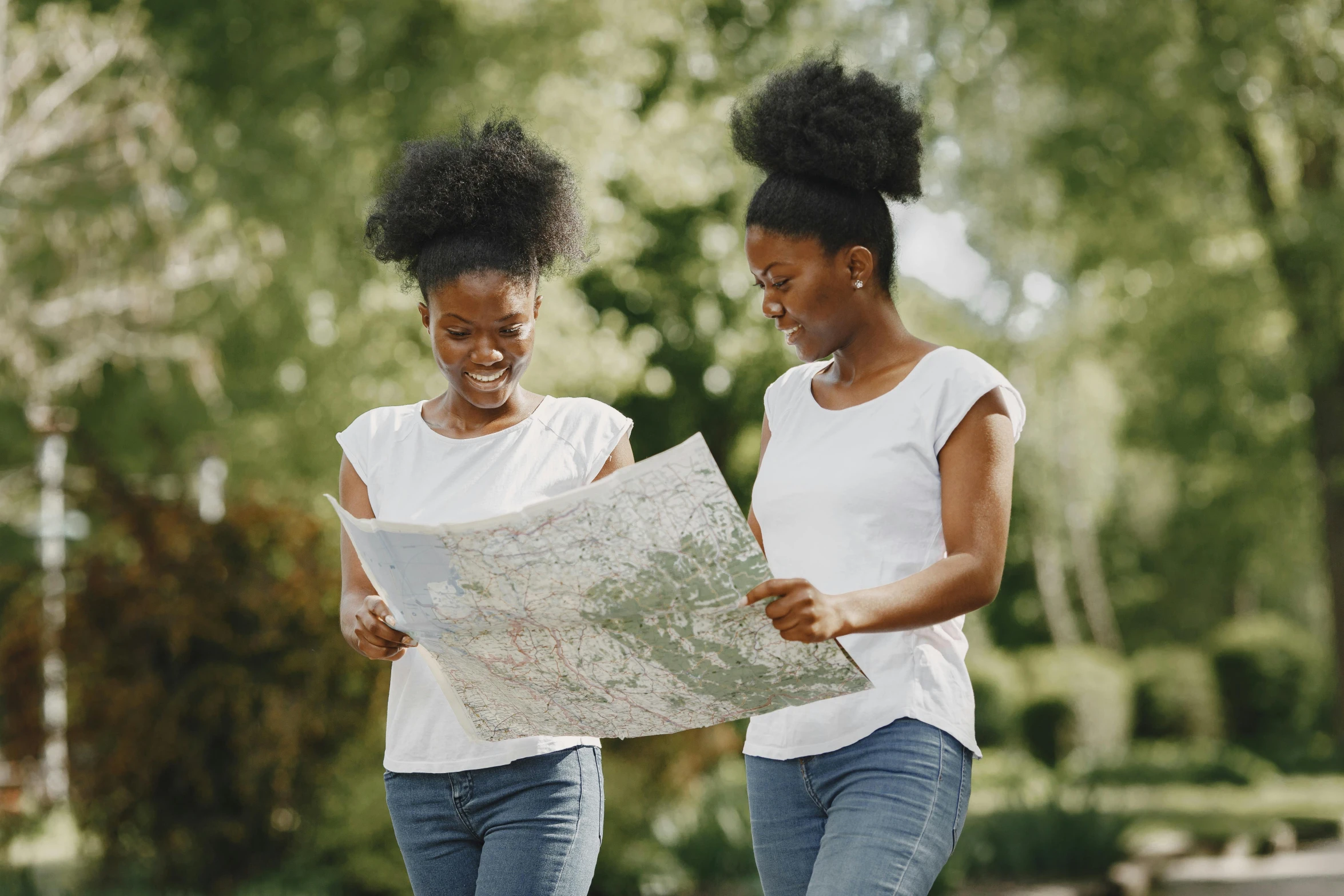 two people walking in the park with a map