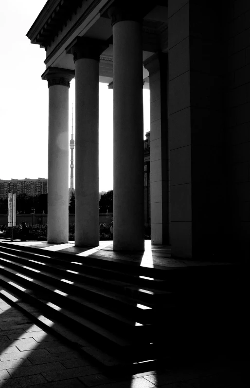 an empty porch with columns and steps leading to buildings