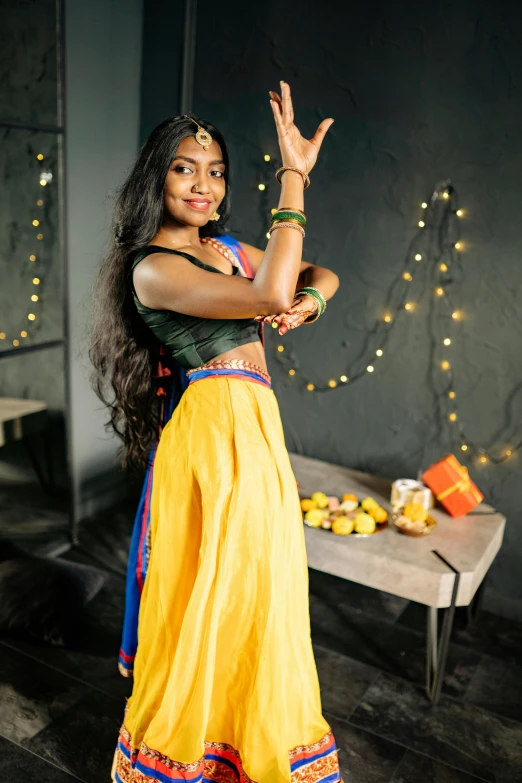 woman in yellow and green clothes standing up with her arms stretched up