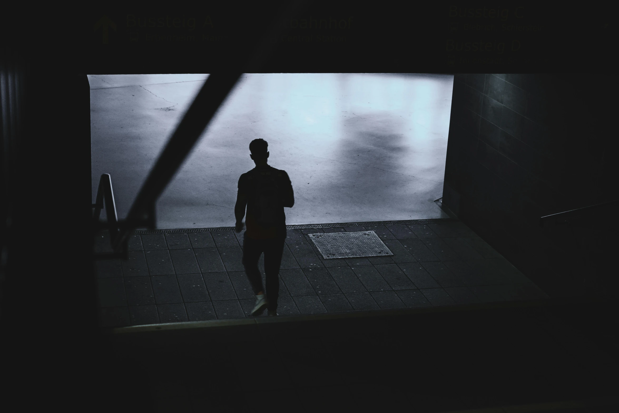 man standing in doorway looking down at soing