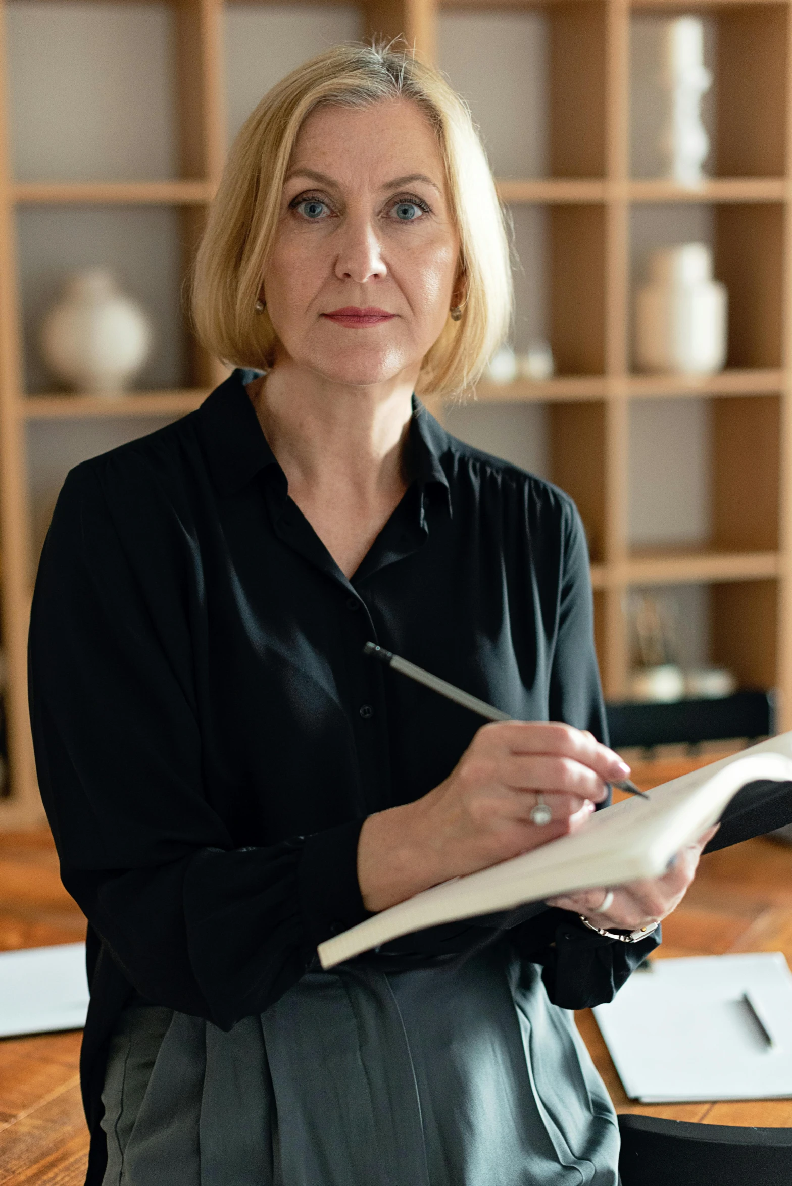 a woman is holding a book and writing