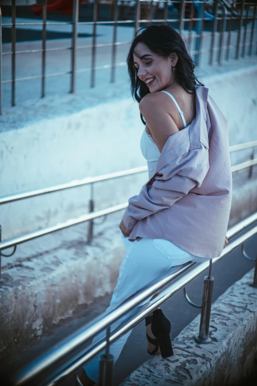 an asian girl sitting down on a bench smiling