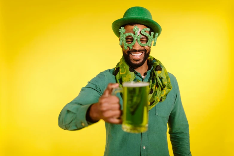 a man with a funny face on holding up a green drink
