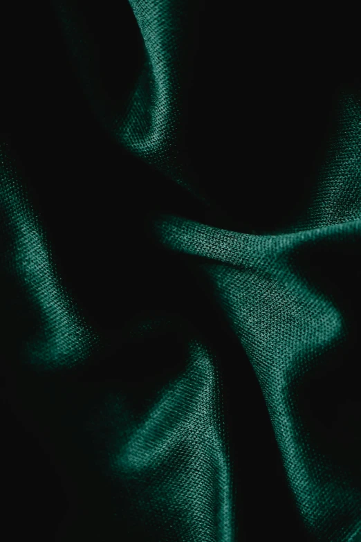 a very dark green fabric background with some lightening