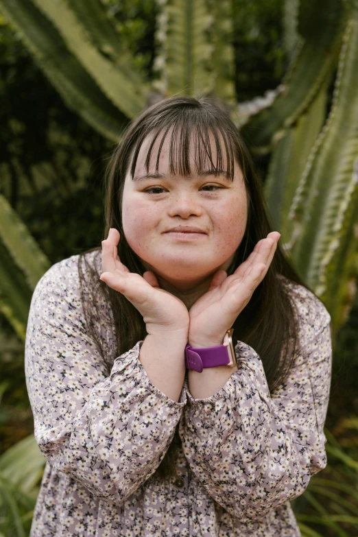 a girl is standing with her hand on her chest