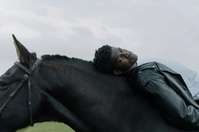 a man on the back of a horse on a cloudy day