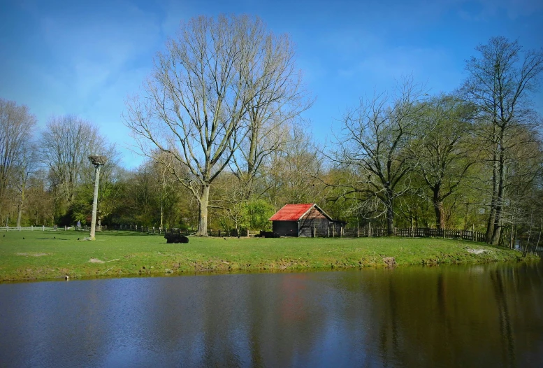 a small barn sitting on the edge of a lake