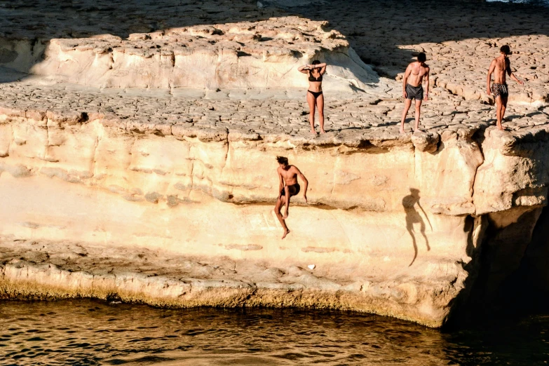 the boys in the swimsuits are diving off the cliffs