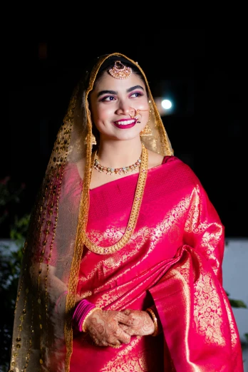 a woman in a pink sari with gold trim