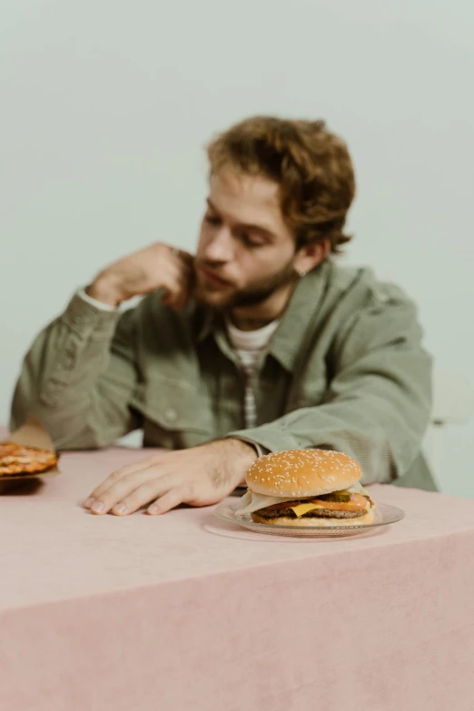 a man sitting at a table and holding a sandwich