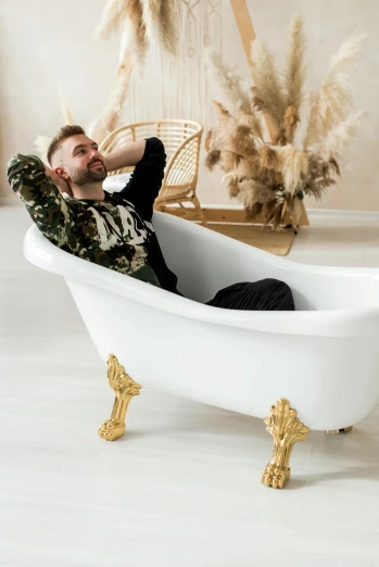 a man sitting in a bath tub while holding his chin resting