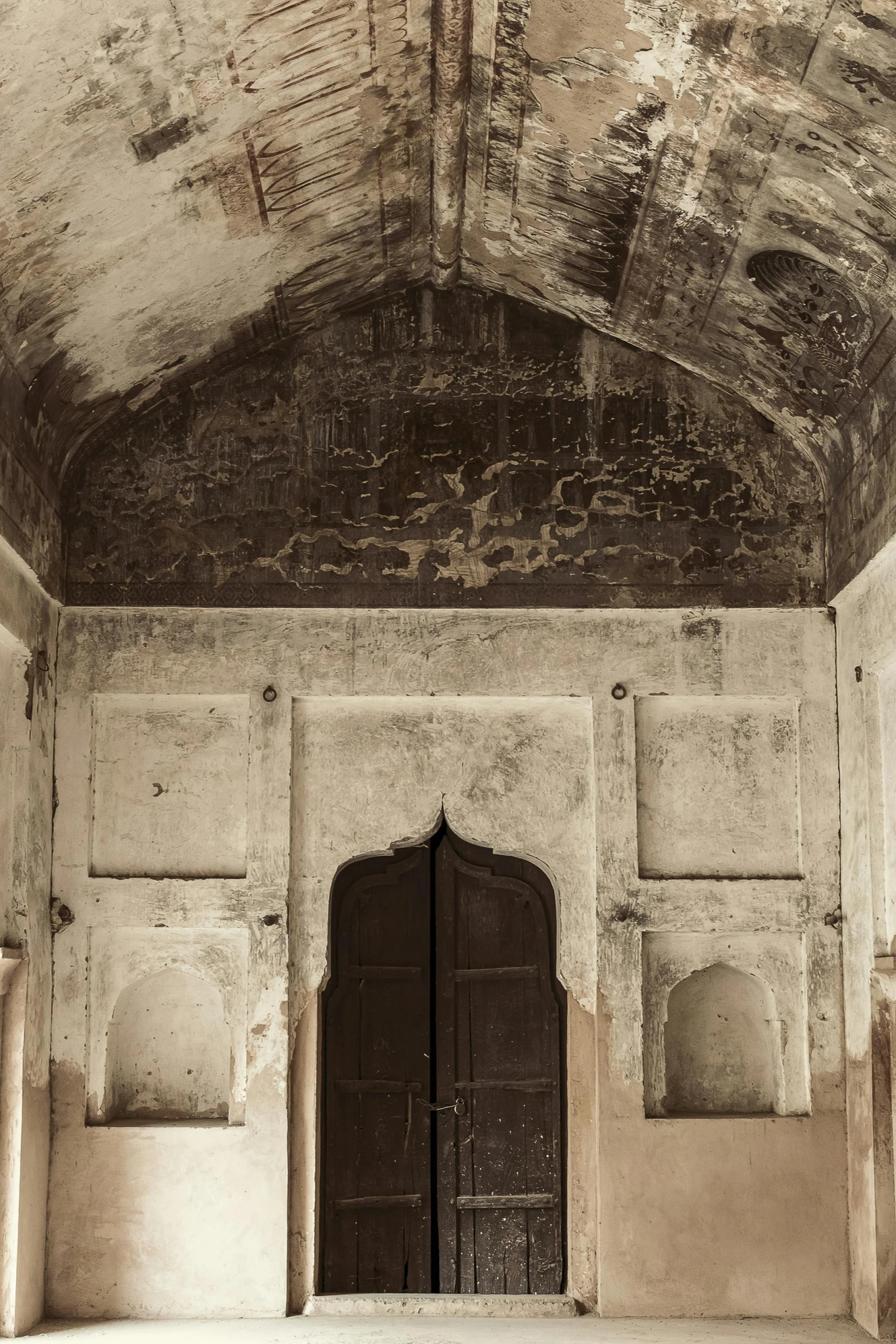 an old looking room with a large brown door