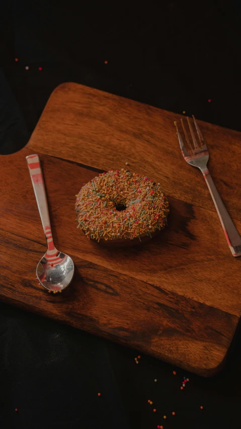 a wooden tray with a donut and fork