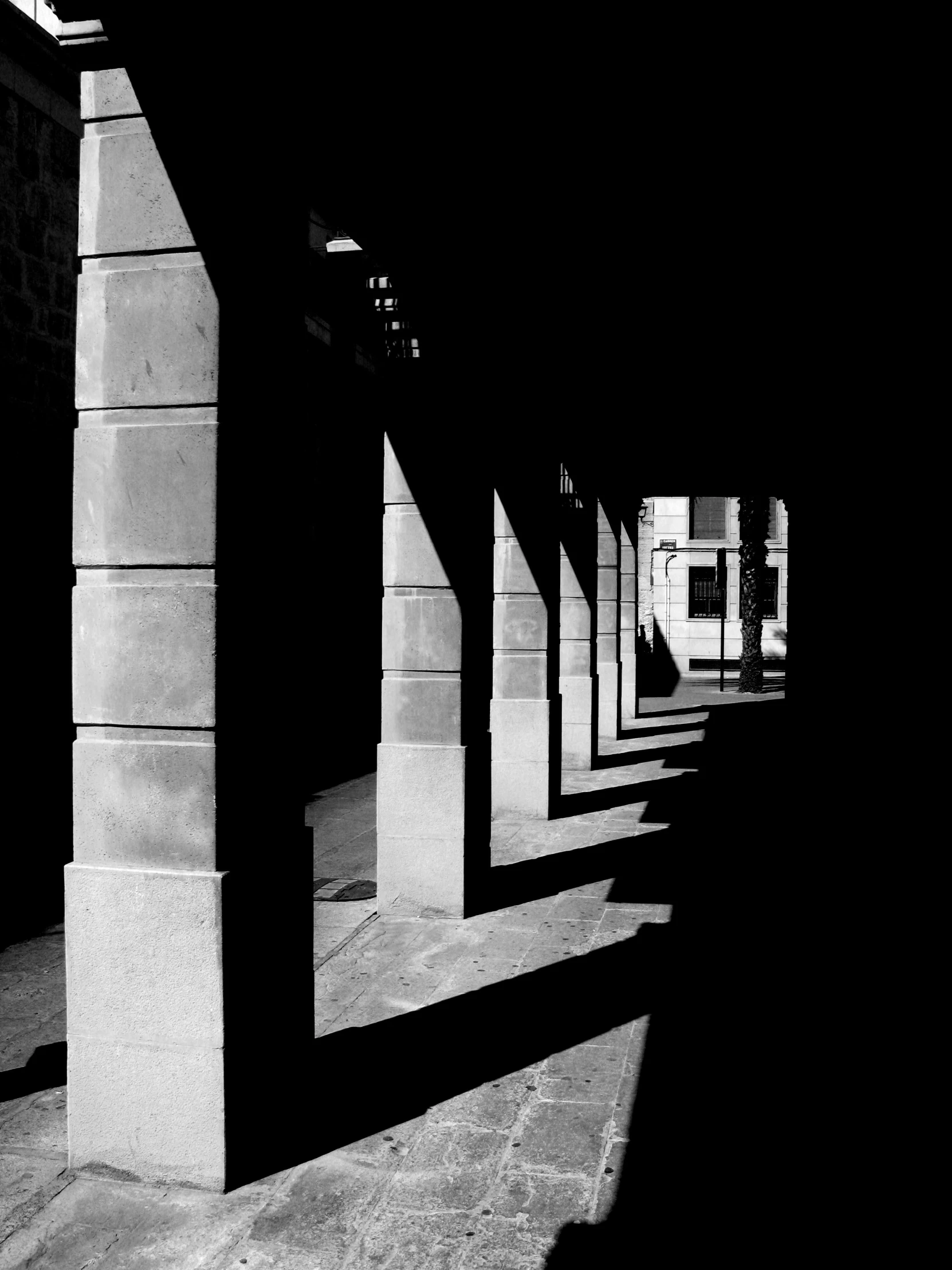 black and white pograph of a row of pillars in a sidewalk