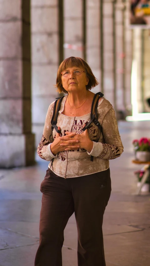 an older woman in wide legged pants walking along the street