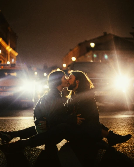 a man and woman sharing an intimate moment on the sidewalk of a city street