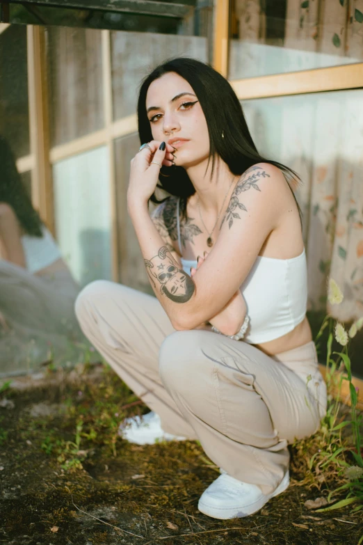 a girl with tattoo smoking cigarette in the grass