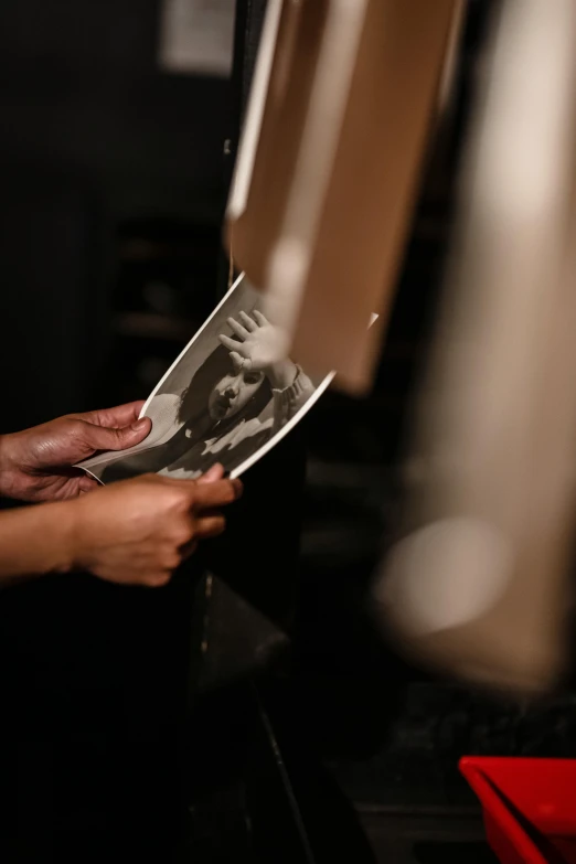 a woman holding a po next to a lamp and some papers